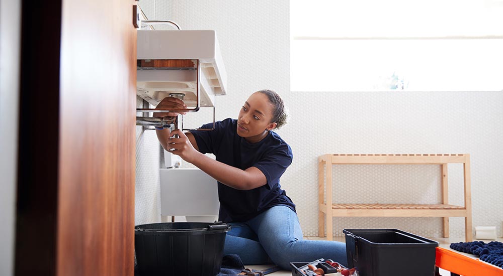 Licensed plumber repairing a sink