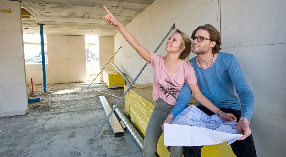 Young couple with blueprints for their new home