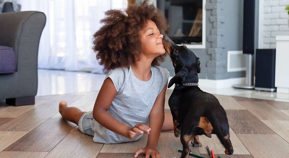 Little girl playing with her pet dog