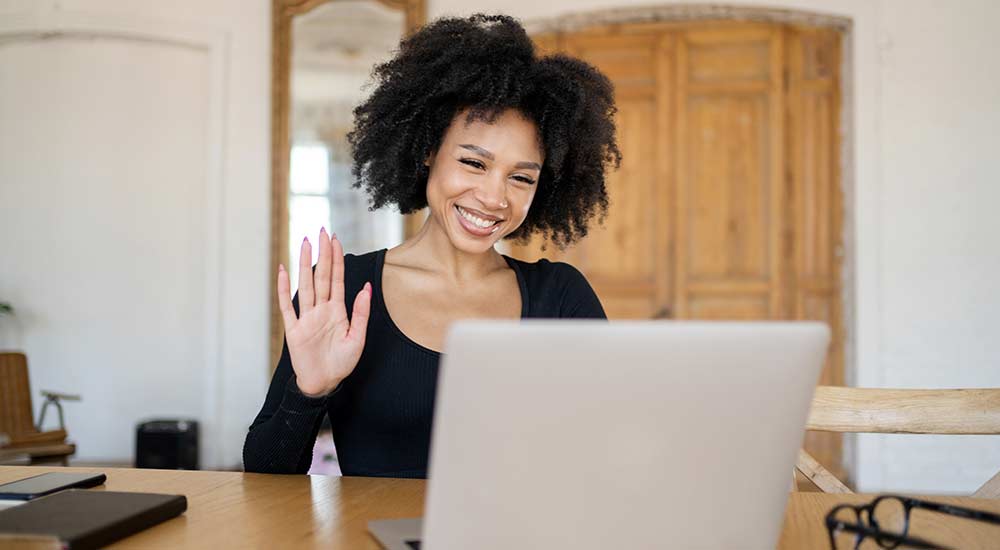 Woman waving in a video chat