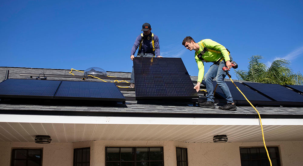 People installing solar panels on a home's roof