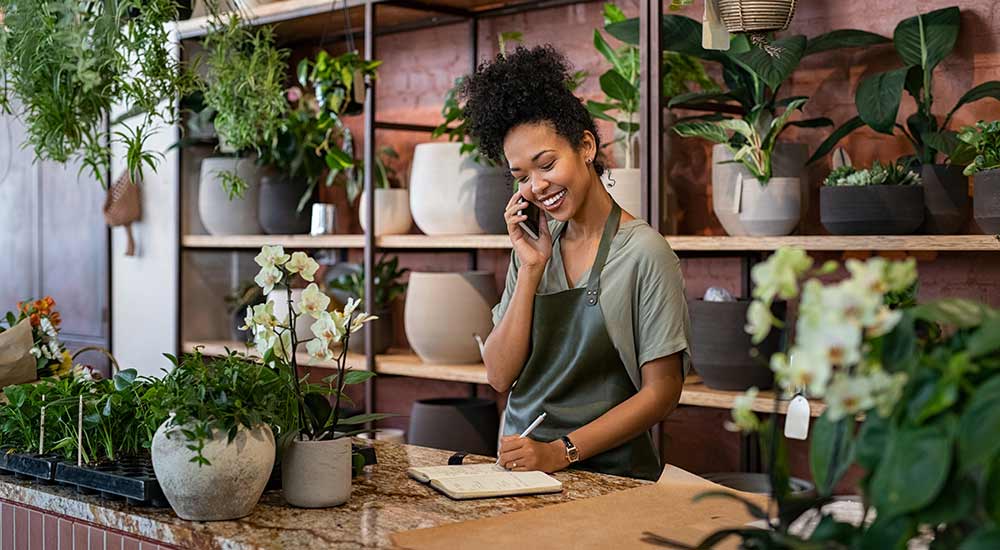 Flower shop owner on the phone with a customer